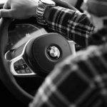 Chauffeur VTC devant sa berline noire dans une rue urbaine parisienne