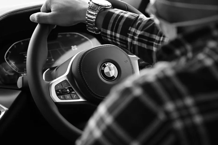Chauffeur VTC devant sa berline noire dans une rue urbaine parisienne