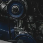 Mécanicien démontant une culasse moteur dans un atelier automobile