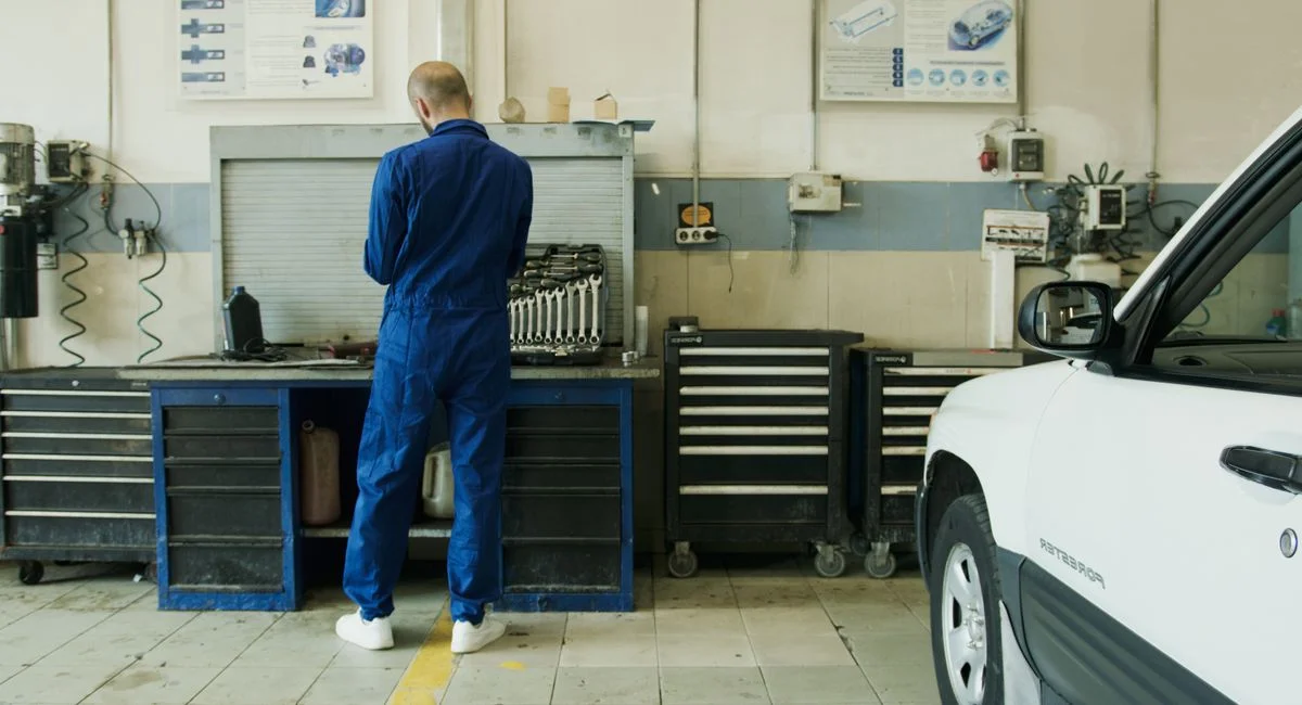 Mécanicien en atelier Citroën inspectant un véhicule avec outillage professionnel