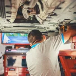 La courroie de distribution Peugeot : le vrai calendrier que votre garage oublie de vous donner Mécanicien inspectant une courroie de distribution sur moteur Peugeot en atelier