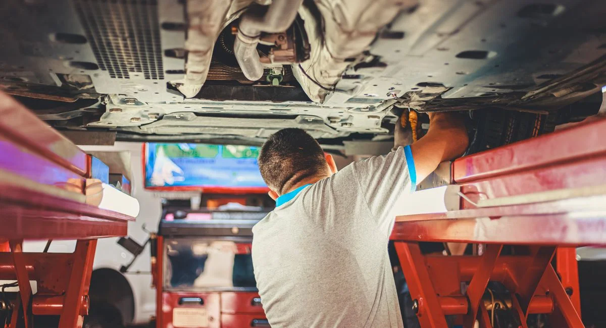 Mécanicien inspectant une courroie de distribution sur moteur Peugeot en atelier
