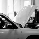 Tableau de bord allumé, moteur muet : pourquoi votre voiture refuse de démarrer Mécanicien testant la batterie d'une voiture avec un multimètre sous le capot