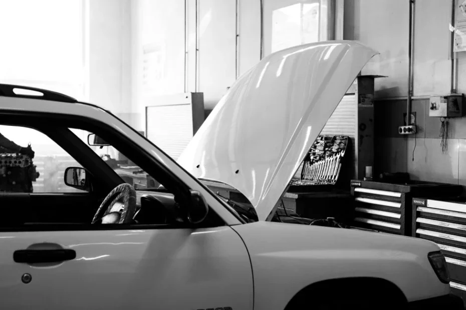 Mécanicien testant la batterie d'une voiture avec un multimètre sous le capot