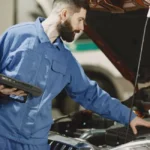 Mécanicien testant la batterie d'une voiture qui ne démarre pas