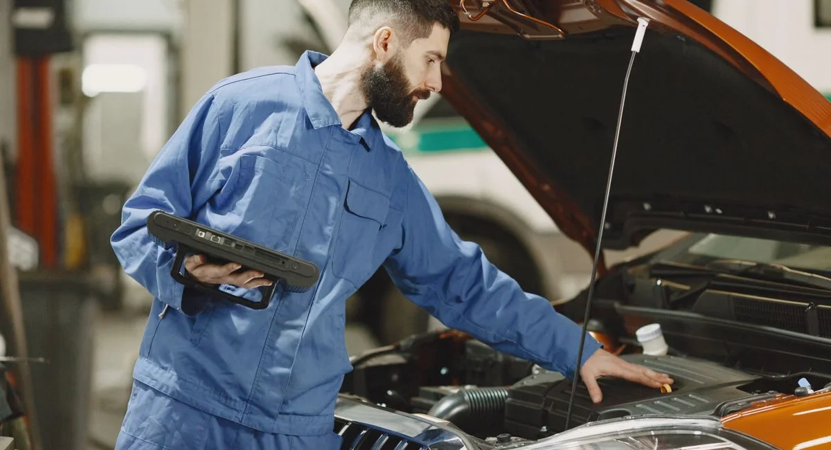 Mécanicien testant la batterie d'une voiture qui ne démarre pas