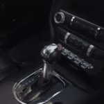 Vidange boîte automatique chez Norauto : vérités que personne ne vous dit Technicien Norauto effectuant une vidange de boîte automatique sur une voiture surélevée