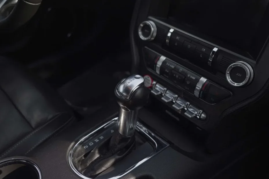Technicien Norauto effectuant une vidange de boîte automatique sur une voiture surélevée
