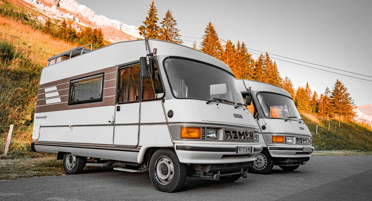 Camping-car garé sur une aire, propriétaire affiche panneau urgent à vendre