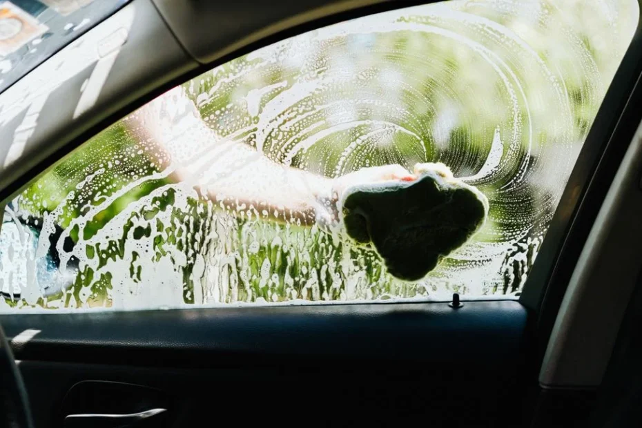 Gros plan sur une main tenant des jetons lavage devant une station auto