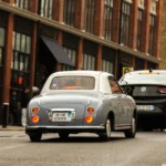 Les marques automobiles qui commencent par E : entre légendes disparues et révolution électrique Véhicules de collection et électriques garés sur une avenue urbaine