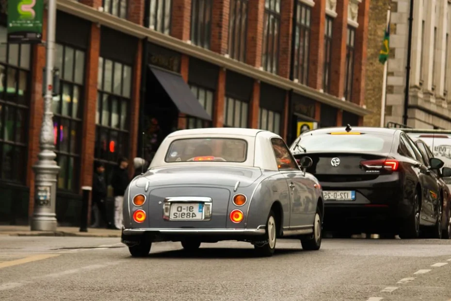 Véhicules de collection et électriques garés sur une avenue urbaine