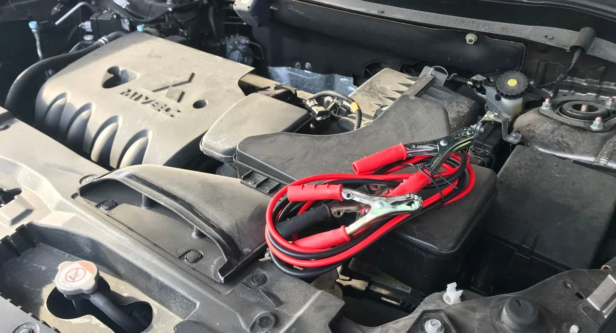 Mécanicien contrôle batterie sur moteur Peugeot, capot ouvert, garage éclairé