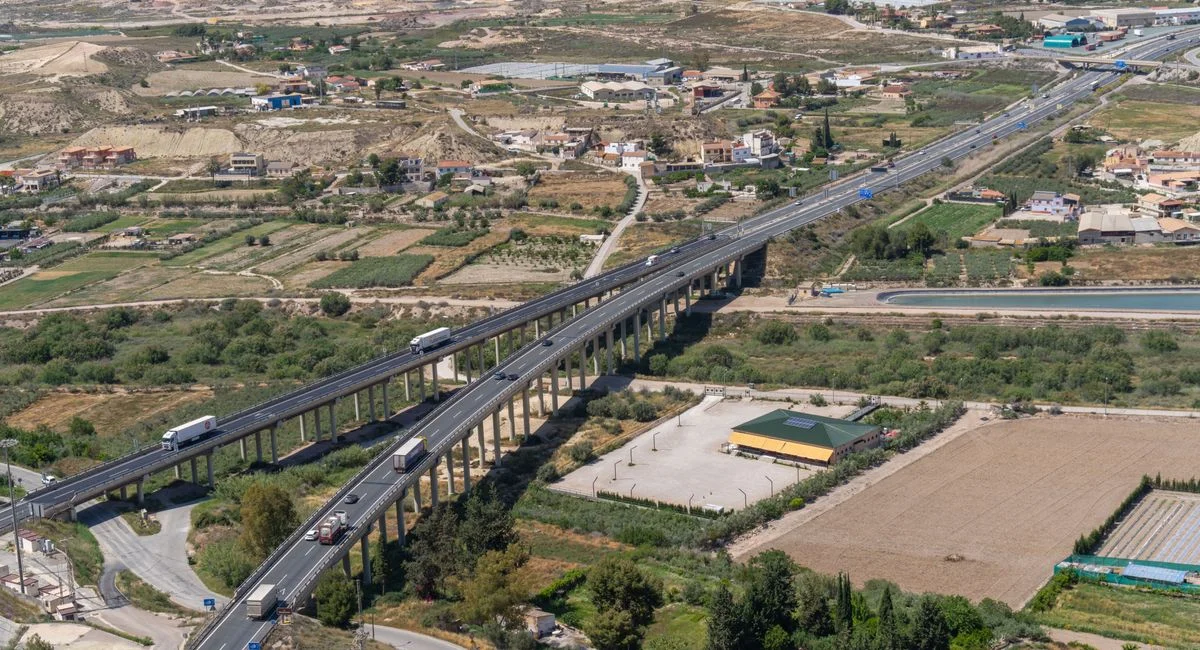 Scenic aerial shot of a highway running through pastoral farmland in Lorca, Murcia, Spain.